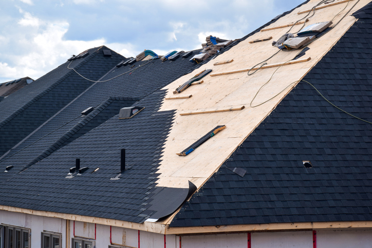 Partially constructed roof with wooden decking and shingles