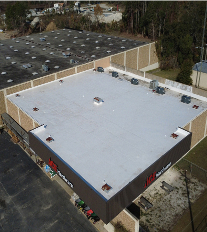 Aerial view of a large warehouse with a flat white roof and HVAC units.